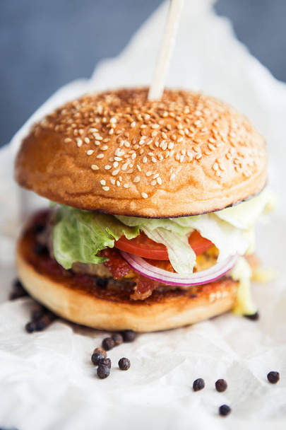 Burger mit Pfeffer auf dem Butterpapier - Foto, Bild