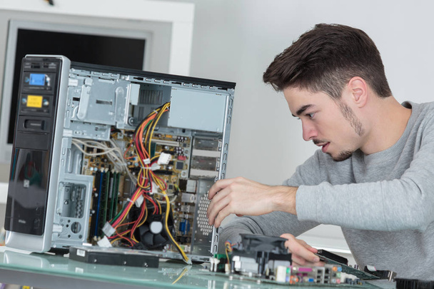 Young computer repairman at work - Фото, изображение