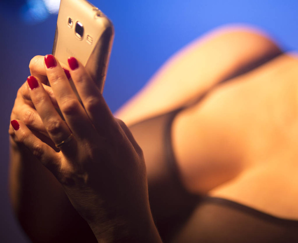 Sexy velmi velká prsa busty dáma pomocí mobilního telefonu v erotické spodní prádlo. - Fotografie, Obrázek