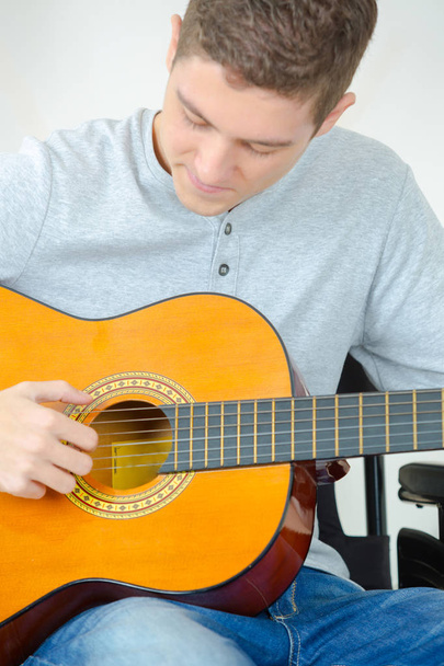young man playing guitar and composing a song - Foto, imagen