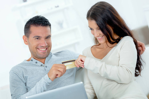 ζευγάρι υποστηρίζοντας παιχνιδιάρικα πάνω από πιστωτική κάρτα - Φωτογραφία, εικόνα