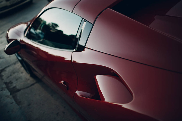 Carro vermelho luxuoso ao pôr-do-sol
 - Foto, Imagem