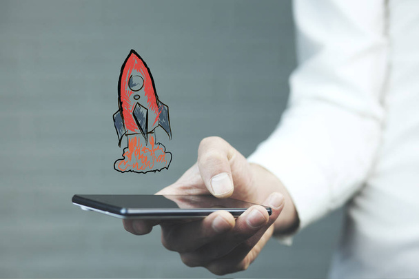 Businessman with phone with red rocket above  - Φωτογραφία, εικόνα