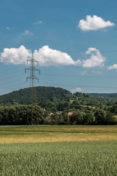 Pylône électrique dans la campagne allemande avec forêts, champs et prairies
 - Photo, image