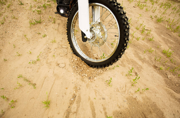 Dirtbike front wheel on muddy rural road in countryside. - Photo, Image