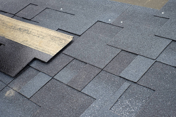 Installing asphalt roofing shingles. Installation of waterproofing coating in construction. - Photo, Image