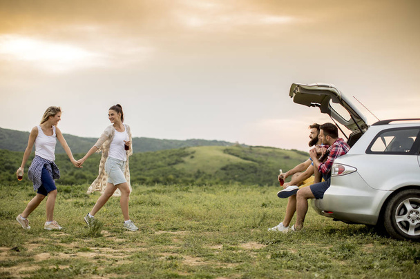 Gruppe junger Leute sitzt während einer Fahrt in der Natur im Auto - Foto, Bild