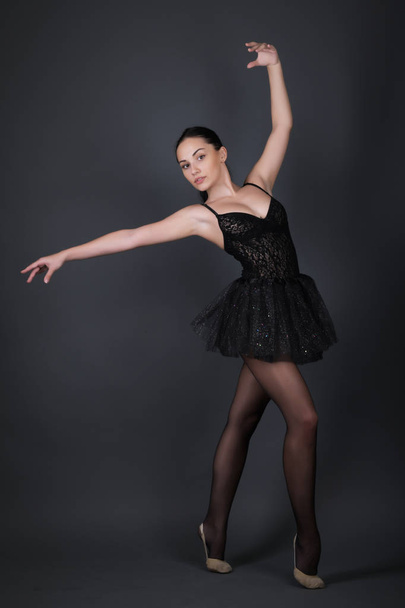Ballerina in black outfit posing in studio. - Фото, зображення