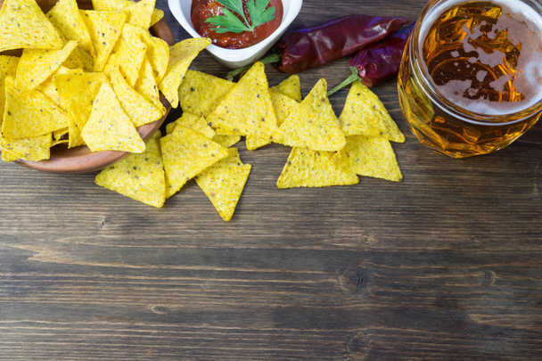 Nachos corn chips with classic tomato salsa. Fresh cold beer is perfect with savory snacks... - Fotografie, Obrázek
