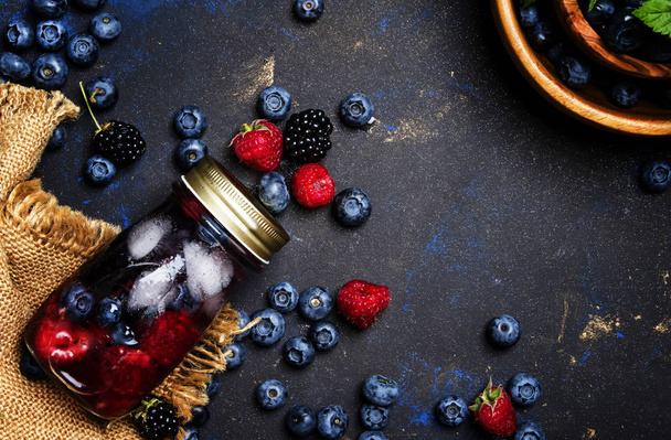 Summer ice berry tea with blueberries, raspberries, blackberries and ice, top view - Photo, Image
