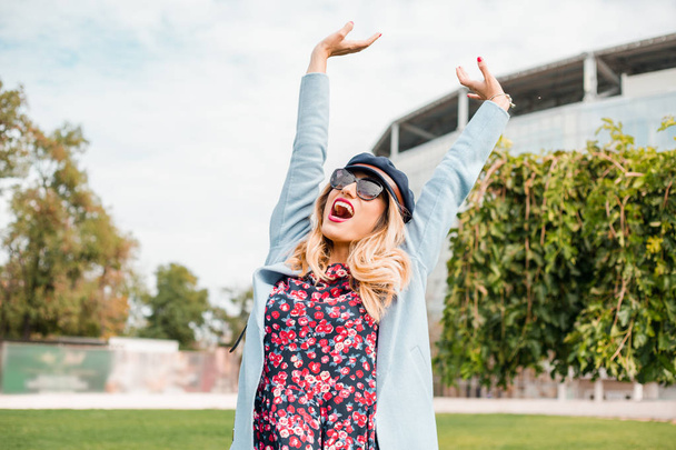 Atractiva mujer rubia con gafas de sol y posando en el parque
 - Foto, Imagen