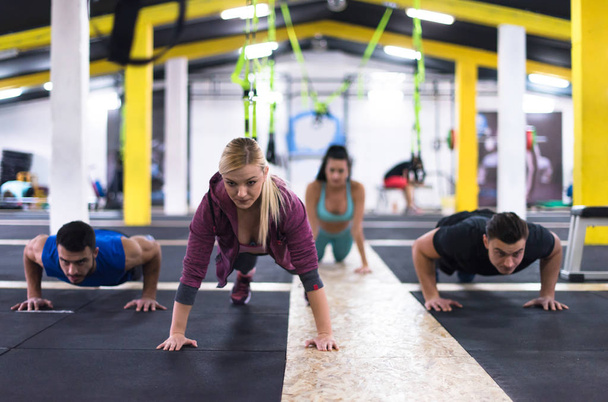 groupe de jeunes gens en bonne santé faisant des pompes à la gym de remise en forme transversale
 - Photo, image