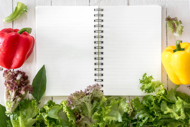 Verduras saludables y cuaderno sobre fondo de madera
 - Foto, imagen