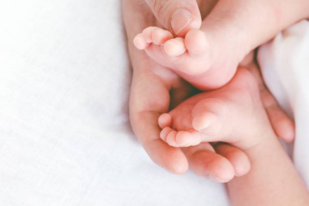 母の手で生まれたばかりの赤ちゃんの足 - 写真・画像