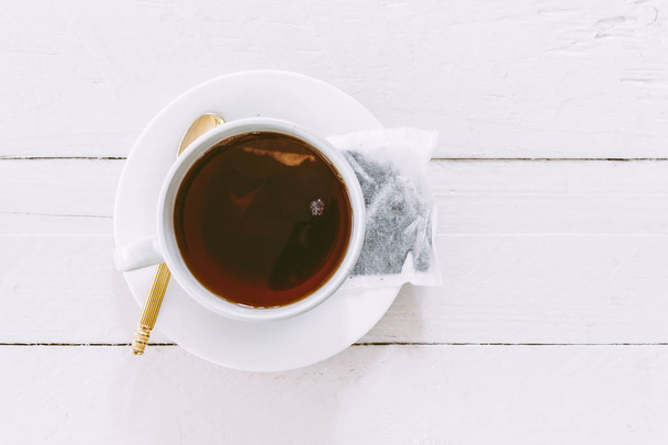 Tasse Tee mit Teebeutel auf Holztisch - Foto, Bild