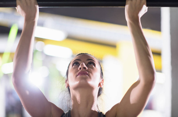 young muscular woman doing pull ups on the horizontal bar as part of Cross fitness Training - Foto, Imagem
