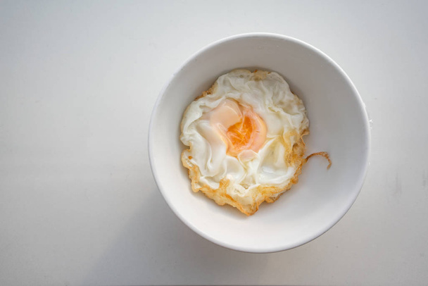 Fechado belo ovo frito em tigela branca isolada no fundo branco. Segurança alimentar servida para o paciente no hospital
. - Foto, Imagem