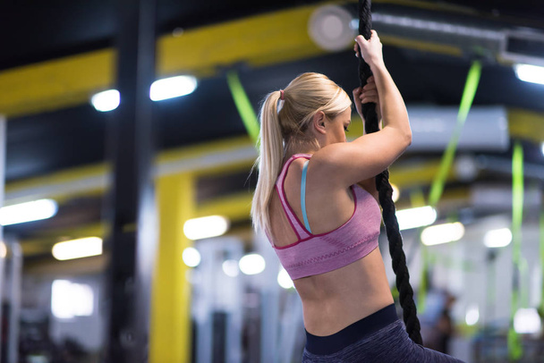 young muscular woman doing rope climbing in cross fitness gym - Φωτογραφία, εικόνα