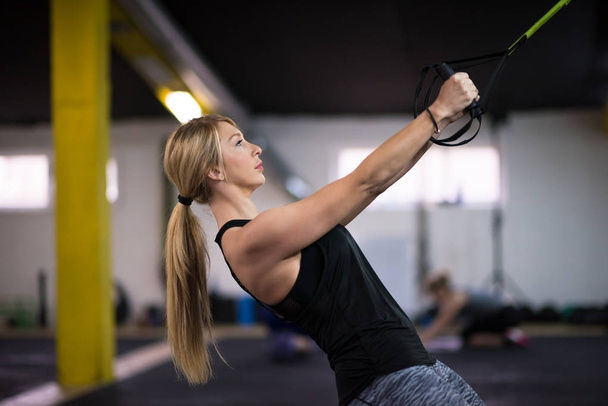 fiatal sportoló nő lekéréses ups torna gyűrű a kereszt fitness edzőteremben kidolgozása - Fotó, kép