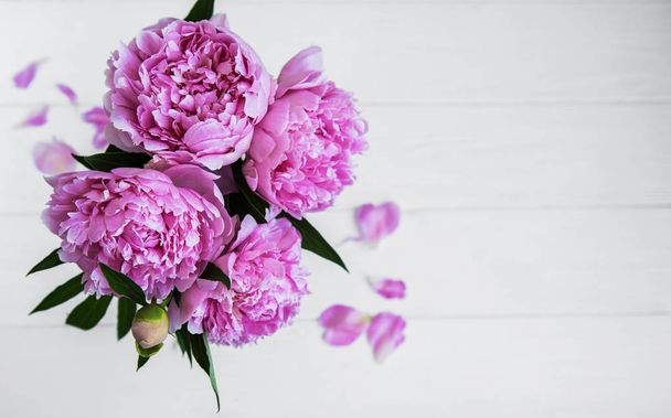 Beyaz ahşap bir masa pembe şakayık çiçekleri - Fotoğraf, Görsel
