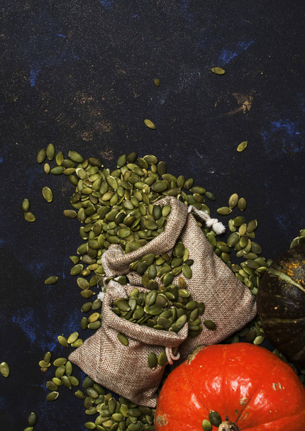Raw pumpkin seeds in canvas bag, food background, top view - Foto, immagini