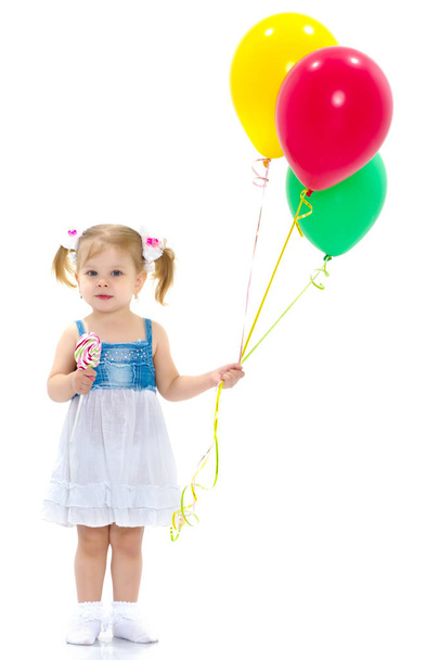Little girl is playing with a balloon - Фото, изображение