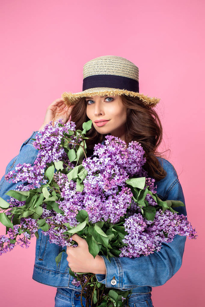Happy smiling woman enjoying smell of bouquet lilac flowers over - Foto, immagini