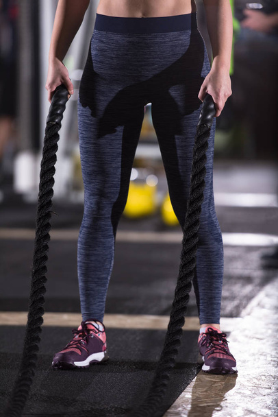 young fit athlete woman working out in functional training gym doing  battle ropes exercise as part of cross fitness training - Fotoğraf, Görsel