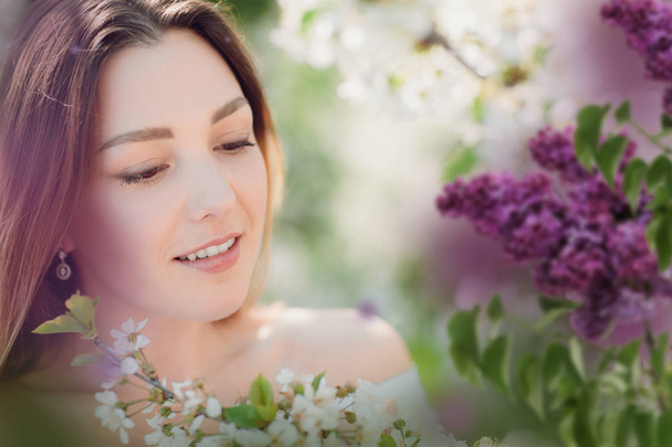 Close up romantic portrait of beautiful elegant woman in blossom spring trees. romantic mood surrounded by flowers - Foto, immagini