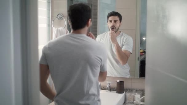 Latino mies harjaamalla hampaat kylpyhuoneessa aamulla rutiini
 - Materiaali, video