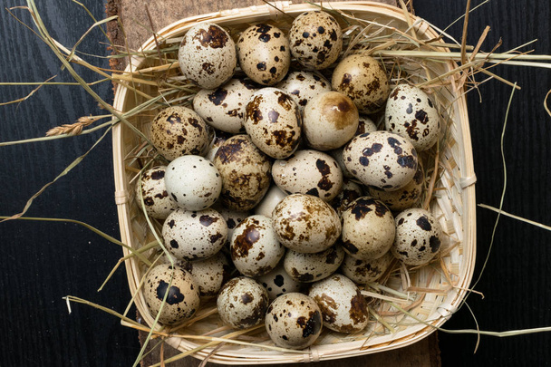 Quail eggs in a nest on a rustic wooden background. Healthy food concept. - Photo, image