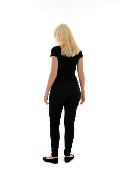 full length portrait of girl wearing black clothing. standing pose on white studio background - Foto, Imagem