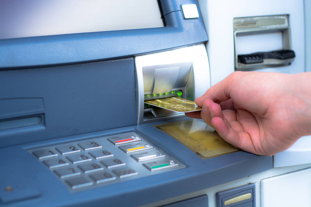 Рука вставляє банкоматну кредитну картку
 - Фото, зображення