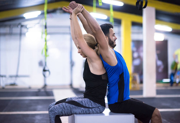 jóvenes atletas de pareja ejercitando sus brazos usando cajas en el gimnasio cross fitness
 - Foto, imagen