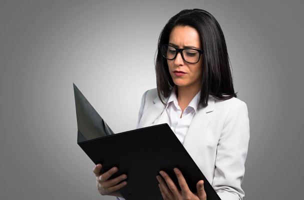 Jolie femme avec des lunettes et tenant liant sur fond gris
 - Photo, image
