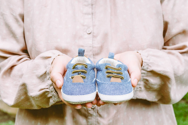 zwanger vrouw met baby schoenen - Foto, afbeelding