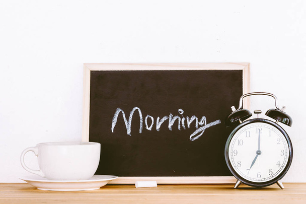Kopje koffie en's ochtends nota over houten tafel - Foto, afbeelding