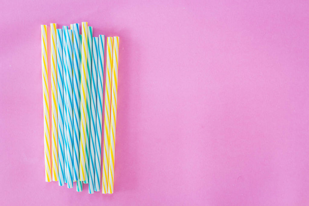 Striped drink straws on pink background - Foto, imagen