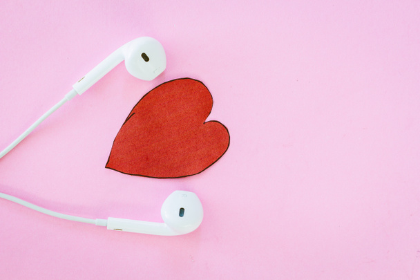 Kopfhörer und Herz auf rosa Hintergrund - Foto, Bild