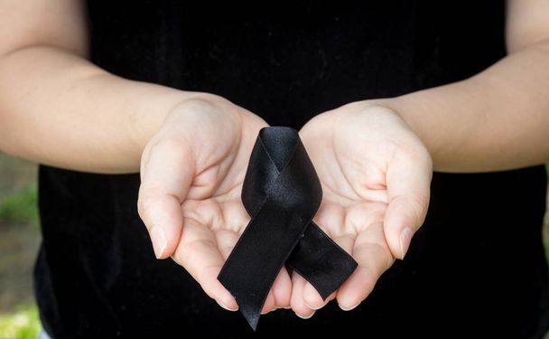 Woman hand holding black ribbon - Photo, Image
