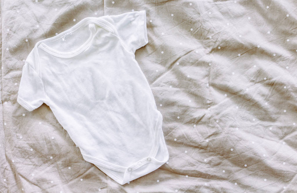 Одежда для ребенка на кровати
 - Фото, изображение