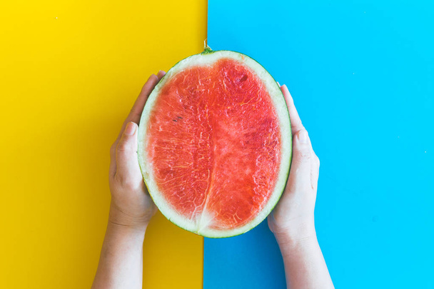 Hand holding watermelon on colourful background - Fotó, kép
