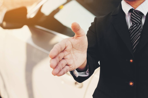 Businessman with an open hand ready to sale car deal - Foto, imagen
