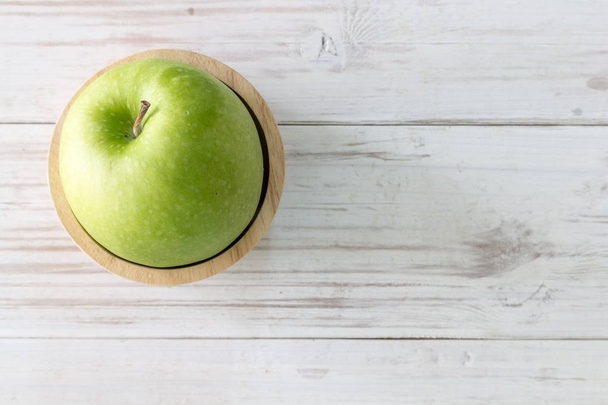 Зеленые свежие яблоки на деревянном столе
 - Фото, изображение