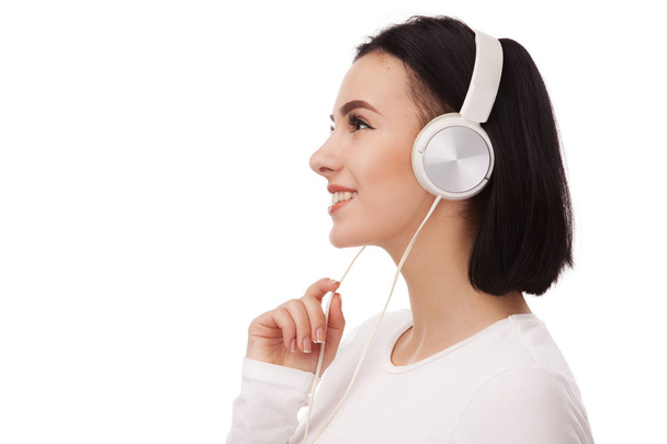 Young beautiful woman in headphones against white background - Photo, image