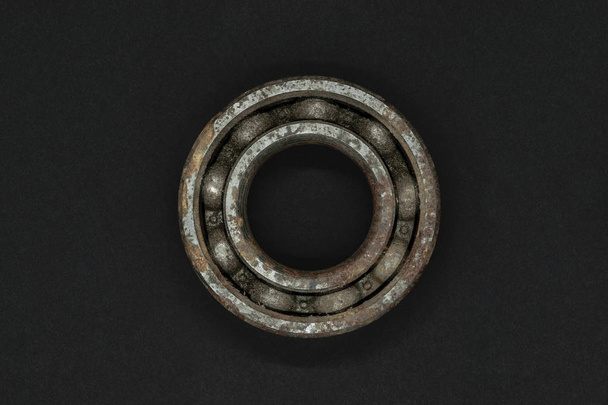 Very old and rusty bearing on black background with free space - Foto, Imagem
