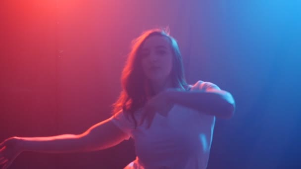 Joven bailarina de estilo moderno sobre un fondo oscuro con humo y luces
 - Imágenes, Vídeo