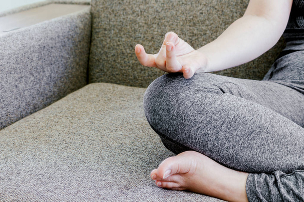Woman practicing yoga at home interior on the sofa - Photo, Image