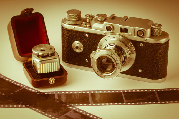 Analog photography .Old analog camera, light meter and film. Vintage toning. Great photos  simple technology: taking pictures without the high-tech. - Photo, Image