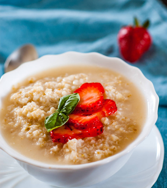Oatmeal porridge with strawberries in bowl on table - Φωτογραφία, εικόνα
